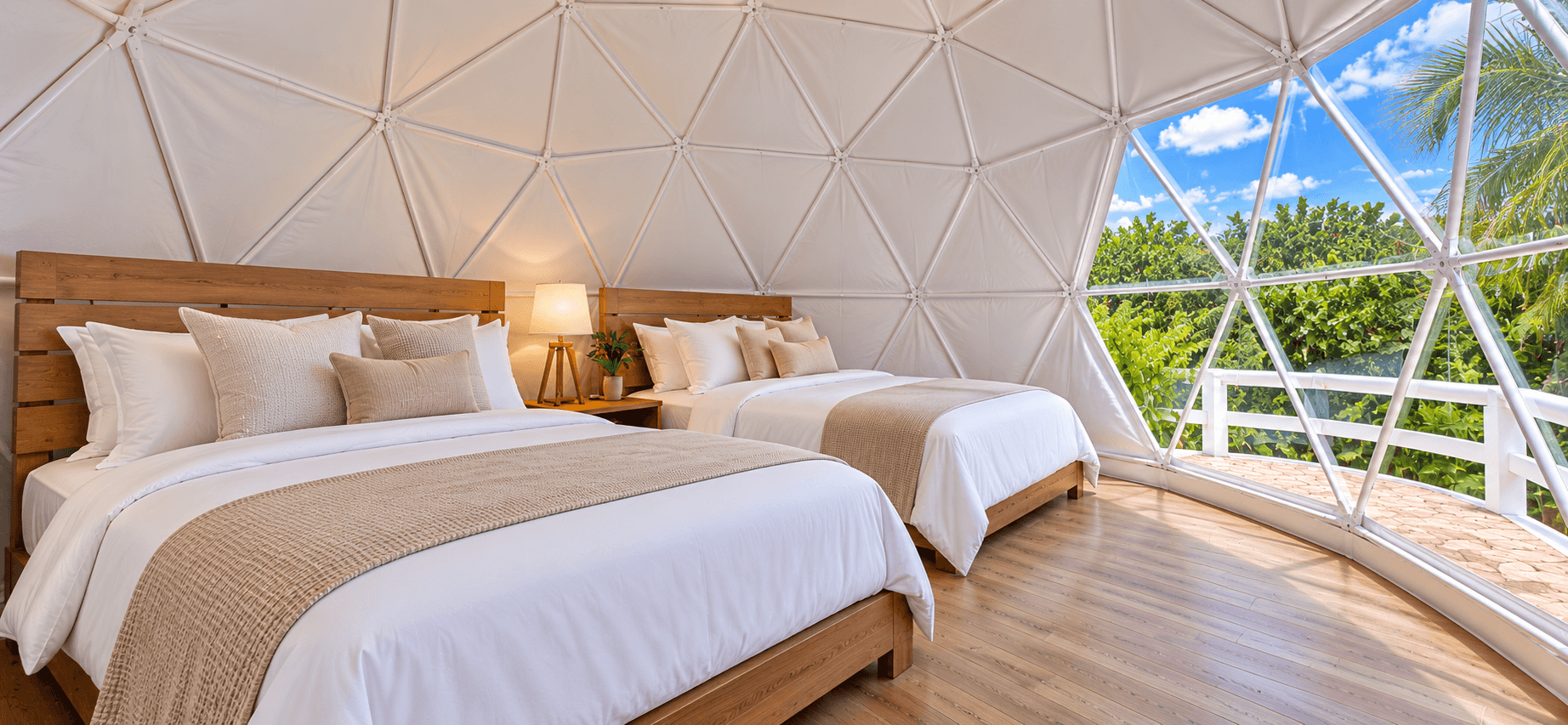 Deluxe Dome interior with two full-sized beds and a glass wall facing the trees